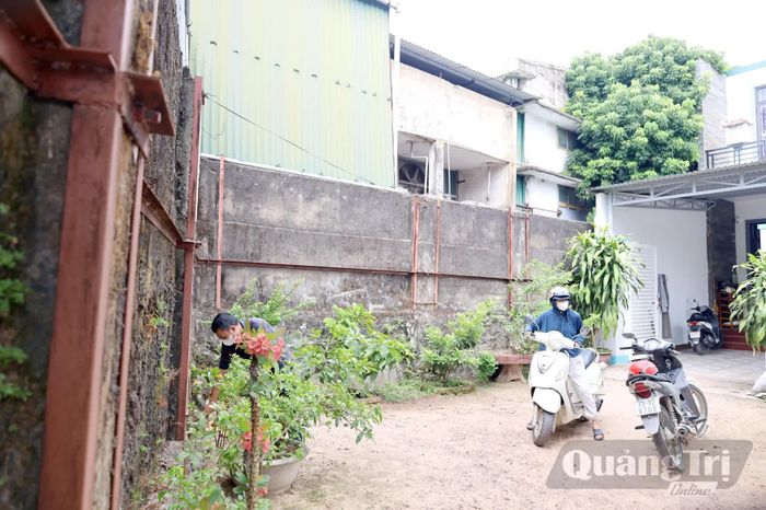 Gia đình ông Hà Ngọc Trung sinh hoạt cạnh tường rào xuống cấp của Nhà máy Bao bì Nhật Lệ - Ảnh: V.Minh