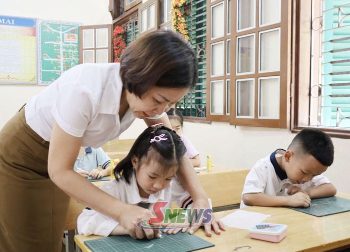 Giáo viên Trường Tiểu học Ít Ong, xã Mường La hướng dẫn học sinh viết chữ.