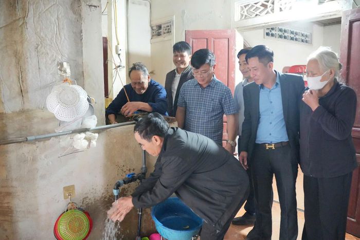 Cán bộ nhà máy nước kiểm tra chất lượng nguồn nước sạch tại nhà dân.