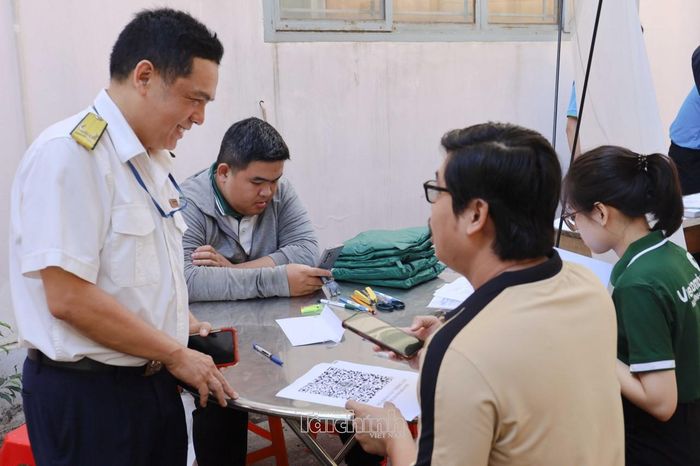 Cán bộ Thuế Cơ sở 26, Thuế TP. Hồ Chí Minh hướng dẫn người nộp thuế kê khai thông tin. Ảnh: Việt Dũng.