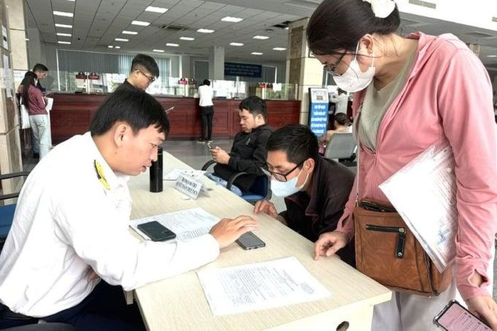 Công chức Thuế Tp. HCM hướng dẫn người nộp thuế dùng ứng dụng Etax Mobile. Ảnh Đỗ Doãn