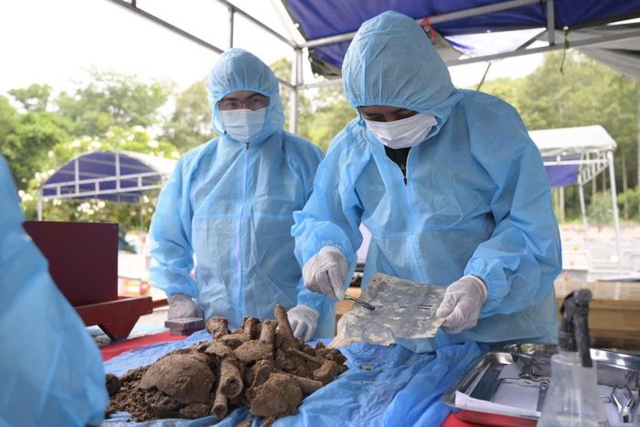 Trong quá trình khai quật phần mộ để lấy mẫu sinh phẩm ADN, lực lượng chức năng phát hiện di vật mang thông tin liệt sĩ Nguyễn Văn Thuận. Ảnh: Phương Vũ