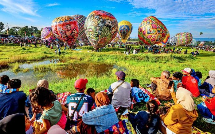 Người dân địa phương theo dõi màn trình diễn khinh khí cầu ngày 29/3 tại huyện Ponorogo, Đông Java - một tỉnh ở phía Đông đảo Java. Chính quyền Ponorogo tổ chức Lễ hội Khinh khí cầu Reog, nhằm quảng bá du lịch và văn hóa trong khu vực. Ảnh: Antara/Muhammad Mada
