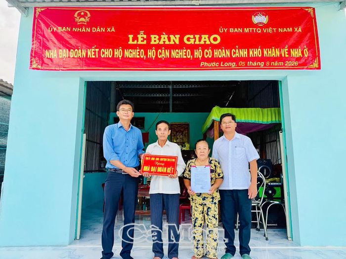 Bí thư Đảng ủy xã Phạm Thành Phước (bìa trái) và Phó Chủ tịch UBND xã Trần Anh Khiêm (bìa phải) bàn giao căn nhà mới cho hộ ông Lê Thanh Hậu.