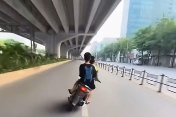 Hình ảnh hai đối tượng lạng lách xe máy trong làn ô tô trên đường Phạm Văn Đồng.
