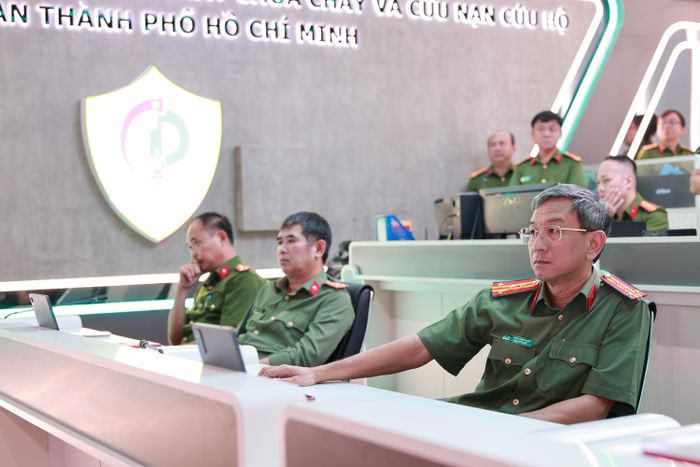 Đại tá Trần Hồng Minh, PGĐ CATP và đại biểu tham quan, theo dõi việc vận hành tại Trung tâm Thông tin Chỉ huy PCCC&amp;CNCH CATP