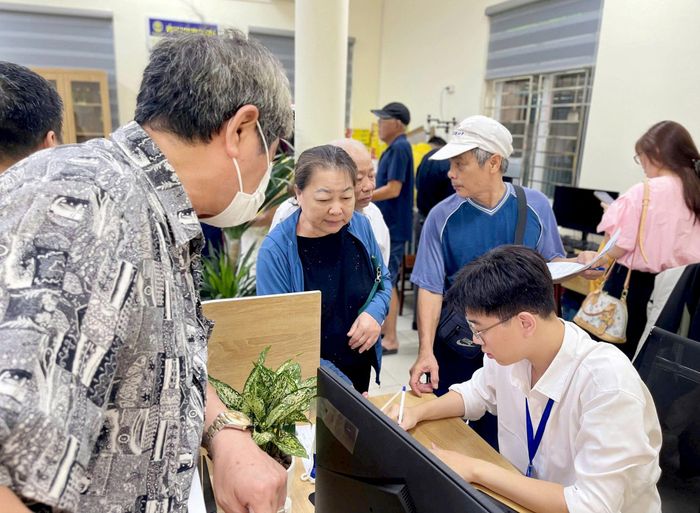 Cán bộ điểm phục vụ hành chính công phường Nghĩa Đô hướng dẫn người dân thực hiện các thủ tục hành chính. Ảnh: MT