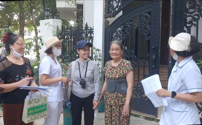 Cán bộ, nhân viên trạm y tế cùng đại diện tổ dân phố đi kiểm tra vệ sinh môi trường và thực hiện phun hóa chất diệt muỗi tại tổ dân phố An Khang. Ảnh: Thu Oanh