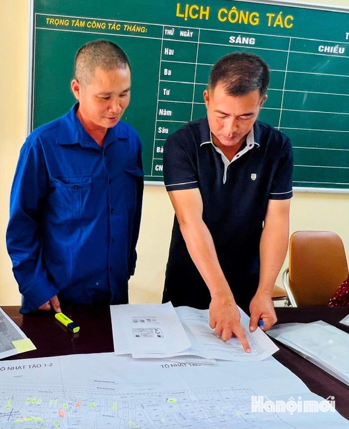 Ông Ngô Đức Anh (phải), hướng dẫn ông Hoàng Minh Tiến đối chiếu thông tin đất đai. Ảnh: Tuệ Lâm