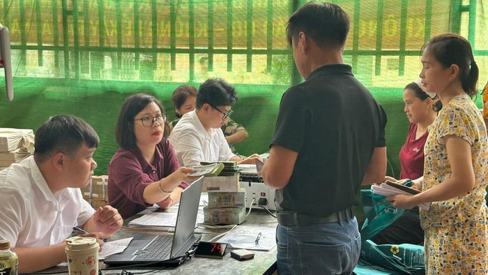 Người dân thôn Thụy Ứng nhận tiền chi trả, bồi thường GPMB dự án đầu tư xây dựng Khu đô thị thể thao Quốc tế Hà Nội. Ảnh: PV