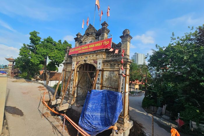 Cổng làng được gia để đảm bảo an toàn trong quá trình nâng. Ảnh: T.Anh