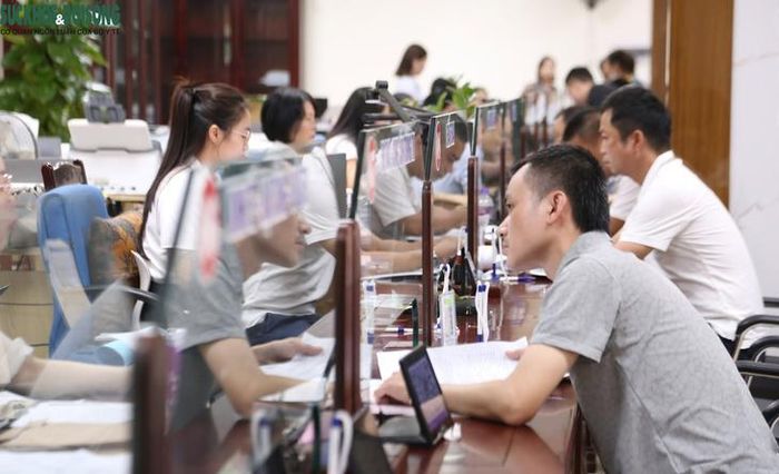 Cán bộ, công chức hướng dẫn, tiếp nhận và giải quyết thủ tục hành chính cho người dân. Ảnh: V. Đồng.
