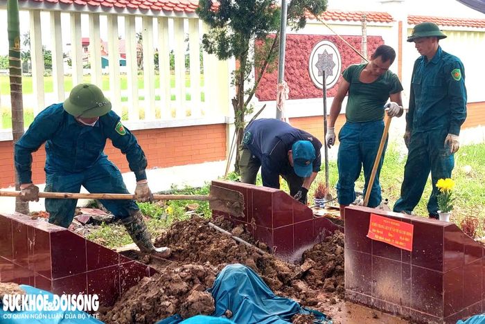 Lực lượng dân quân tự vệ và thôn đội trưởng - Ban CHQS xã Chí Minh đảm nhiệm công tác khai quật mộ liệt sĩ chưa xác định được thông tin để lấy mẫu ADN. Ảnh: Đ.Tùy.