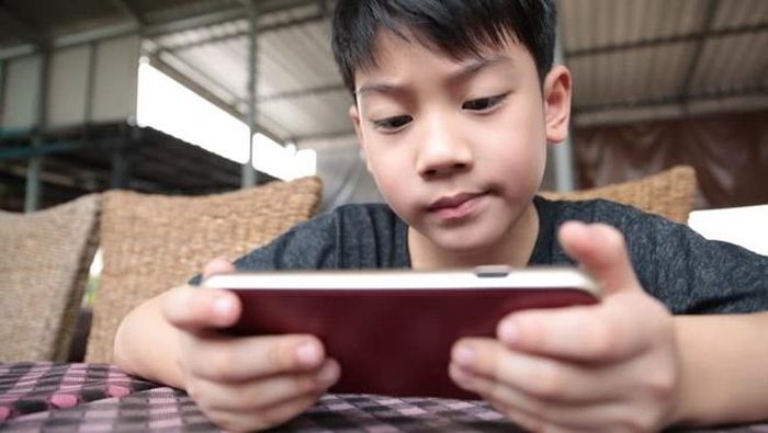 Trẻ đang bị giữ chân bởi smartphone. Ảnh: Shutterstock.