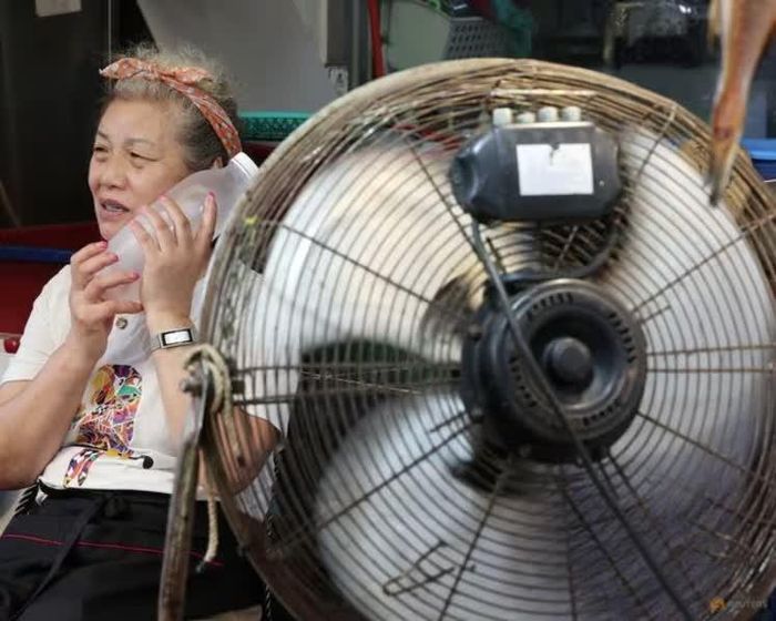  Một tiểu thương dùng chai nước đá hạ nhiệt tại chợ truyền thống ở Seoul khi nhiệt độ tiến sát mốc 39°C, ngày 6/8/2026. Ảnh: Reuters. 