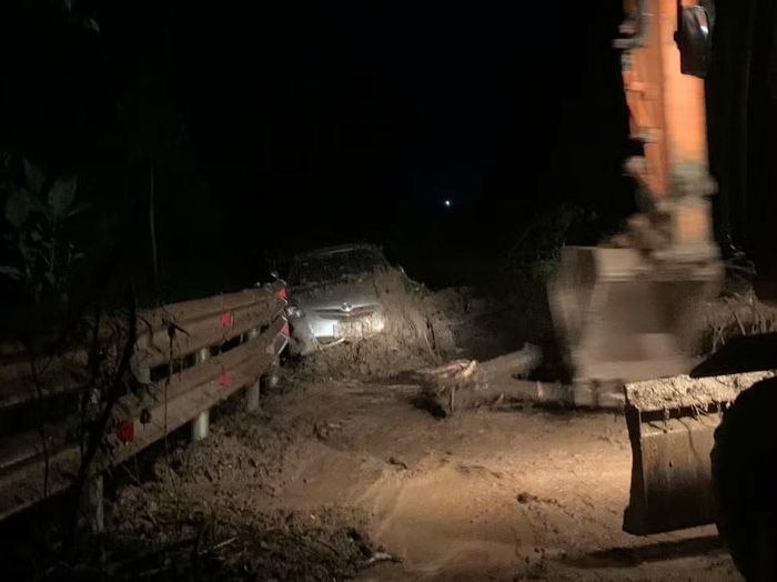 Kéo ô-tô gặp nạn ra khỏi đống vụn đất đá. (Ảnh: Khu Quản lý đường bộ I)