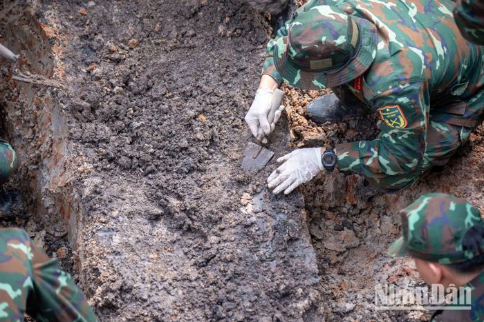 Khi chạm đến tầng đất có dấu hiệu hài cốt, các chiến sĩ dùng bay và tay đeo găng để bóc tách từng lớp đất tỉ mỉ.