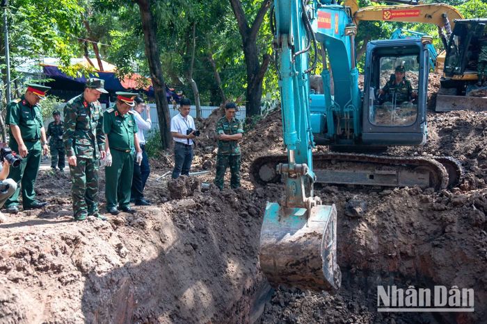 Sau khi sử dụng 5 thiết bị radar lòng đất từ các đơn vị được huy động đến Công viên Lê Thị Riêng để rà tìm dấu vết mộ tập thể liệt sĩ, lực lượng tìm kiếm sử dụng máy xúc để khai quật những vị trí có dấu hiệu của hài cốt.