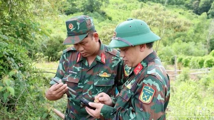 Dùng máy để xác định khu vực có mộ liệt sĩ theo thông tin được cung cấp. (Ảnh: DƯƠNG QUANG TIẾN)