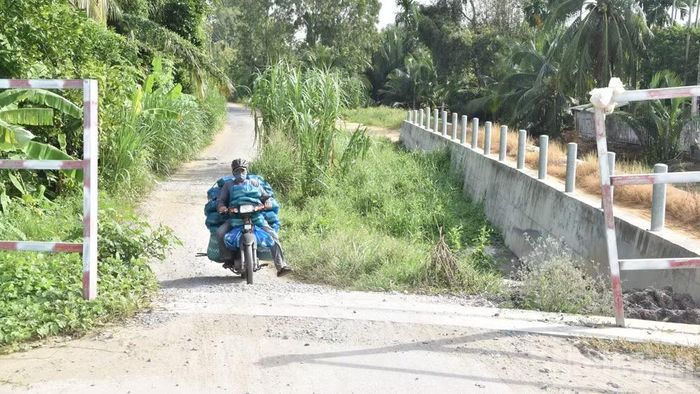 Chưa có đường dẫn, người dân vận chuyển hàng hóa qua cầu gặp nhiều khó khăn.