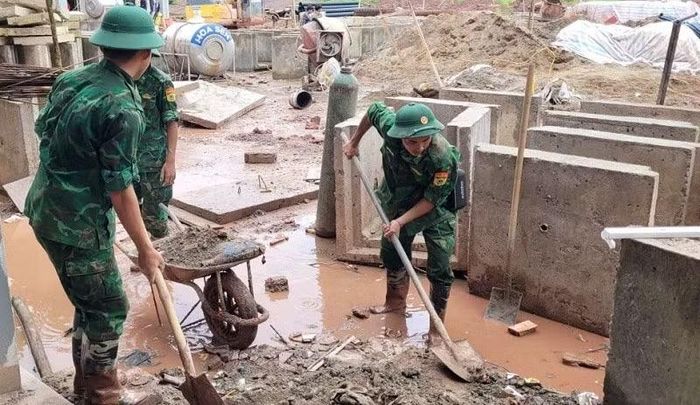 Chiến sĩ Bộ đội Biên phòng Điện Biên chung sức thu dọn vệ sinh quanh các khu xây dựng Trường nội trú liên cấp.