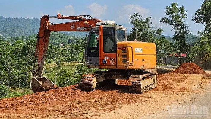 Nhân lực cùng phương tiện cơ giới khắc phục điểm sạt lở đường giao thông ở thượng du Thanh Hóa. (Ảnh: Mai Luận)