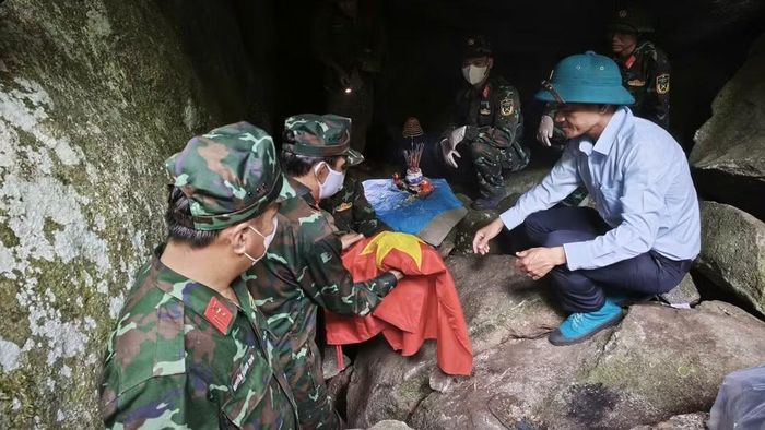 Các lực lượng chức năng bao bọc để đưa hài cốt ra khỏi hang đá. (Ảnh: Phan Tuân)