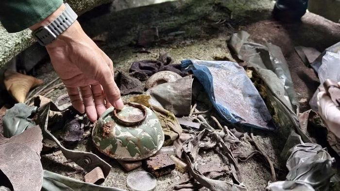 Khi khai quật, lực lượng chức năng phát hiện các di vật liên quan hài cốt liệt sĩ. (Ảnh: Phan Tuân)
