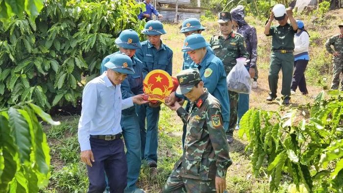 Các lực lượng chức năng đưa hài cốt liệt sĩ về nơi bảo quản, thờ cúng. (Ảnh: Phan Tuân)
