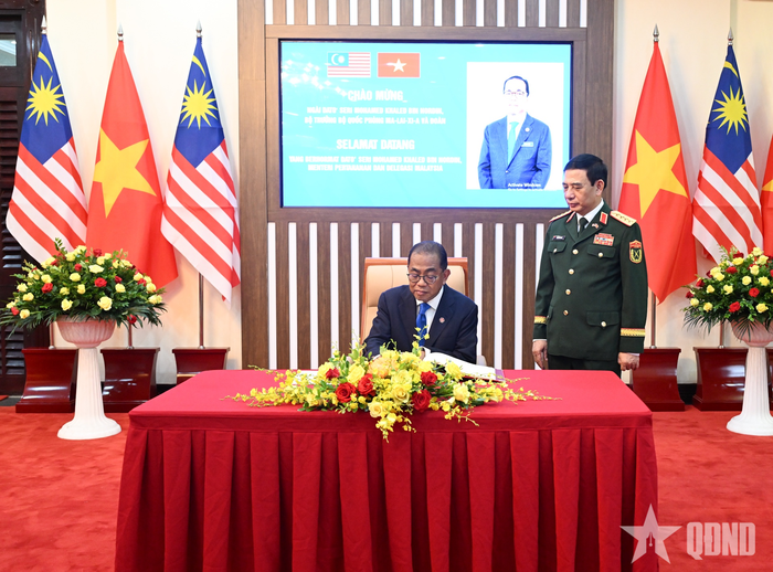 Bộ trưởng Dato' Seri Mohamed Khaled bin Nordin ghi sổ lưu niệm tại trụ sở Bộ Quốc phòng Việt Nam. Ảnh: TRỌNG HẢI 