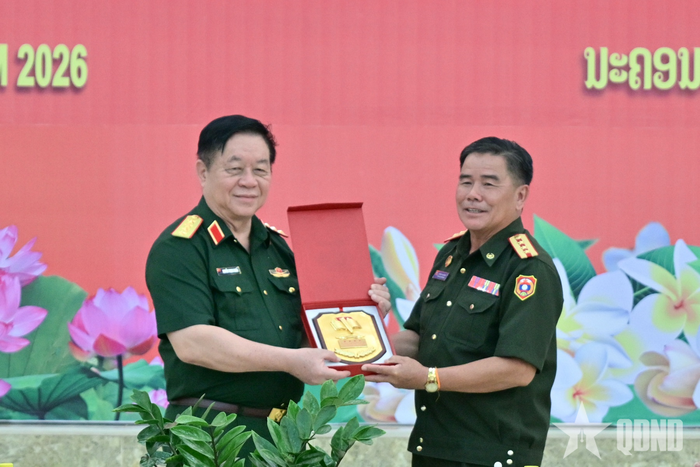Đại tướng Nguyễn Trọng Nghĩa và đại diện lãnh đạo Trường Lý luận Chính trị QĐND Lào trao tặng quà lưu niệm.