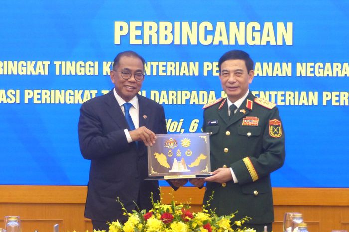 Đại tướng Phan Văn Giang và Bộ trưởng Dato' Seri Mohamed Khaled bin Nordin trao đổi quà lưu niệm sau hội đàm. Ảnh: TRẦN BÌNH