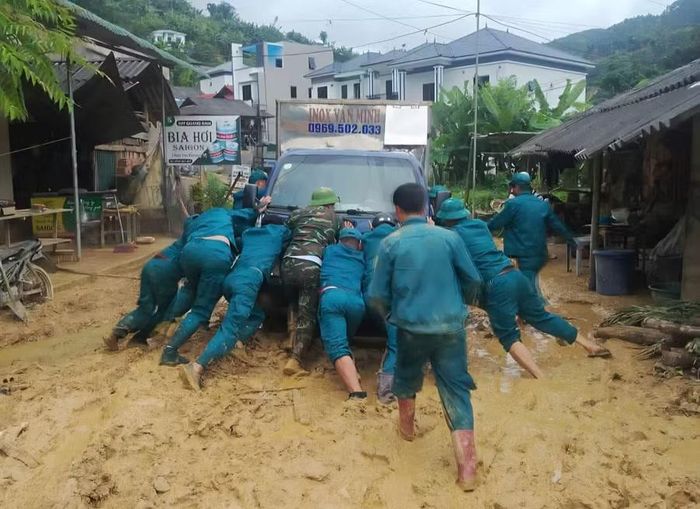 Lực lượng dân quân tự vệ hỗ trợ người dân di chuyển tài sản.