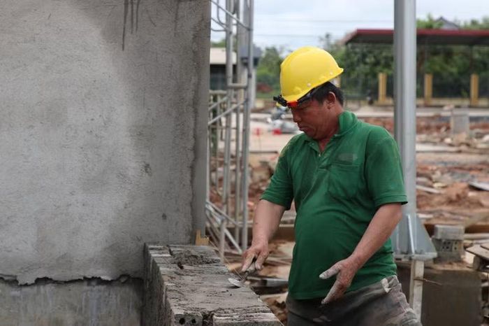 Đôi bàn tay lem luốc của những người thợ đang từng ngày đặt nền móng cho tương lai giáo dục vùng biên. (Ảnh: Thế Hùng)