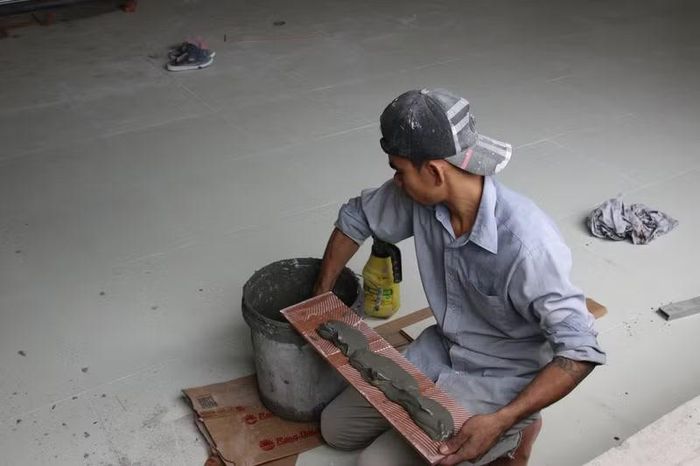 Từng viên gạch được ốp lát, góp phần hoàn thiện không gian học tập khang trang. (Ảnh:Thế Hùng)