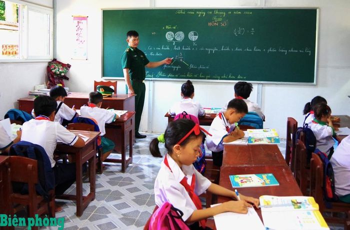 Thầy giáo quân hàm xanh Bộ đội Biên phòng tỉnh Cà Mau dạy học cho trẻ em ở khu vực biên giới. Ảnh: Hoàng Tá