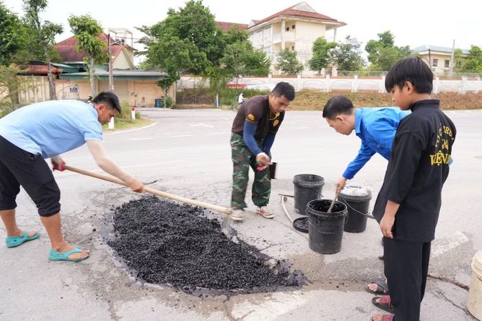Nhóm thiện nguyện của anh Hòa lấp ổ gà trên một tuyến đường ở xã Kim Liên.