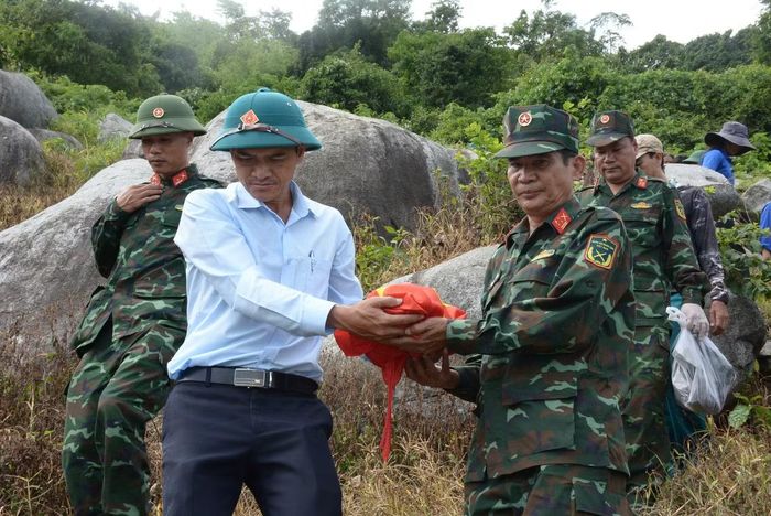 Cán bộ, chiến sĩ Đội K51 đưa hài cốt liệt sĩ ra khỏi hang đá. (Ảnh: Anh Hùng)