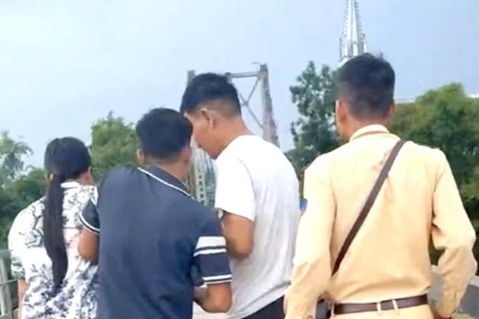 Lực lượng CSGT kịp thời giải cứu người phụ nữ có ý định nhảy cầu tự vẫn. (Ảnh: TP)
