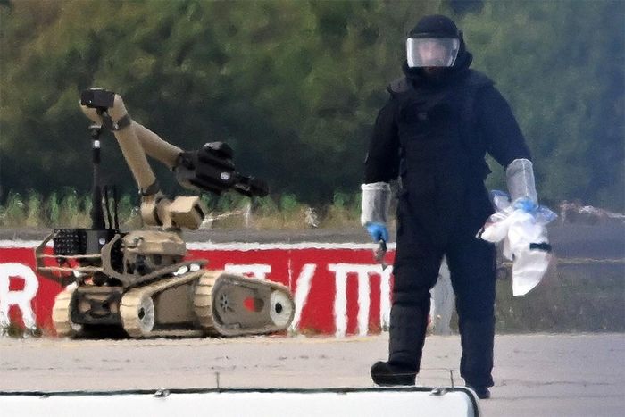 Một kỹ thuật viên pháp y làm việc cùng robot xử lý bom tại sân bay Leipzig, Đức ngà 5/8. Ảnh: DPA