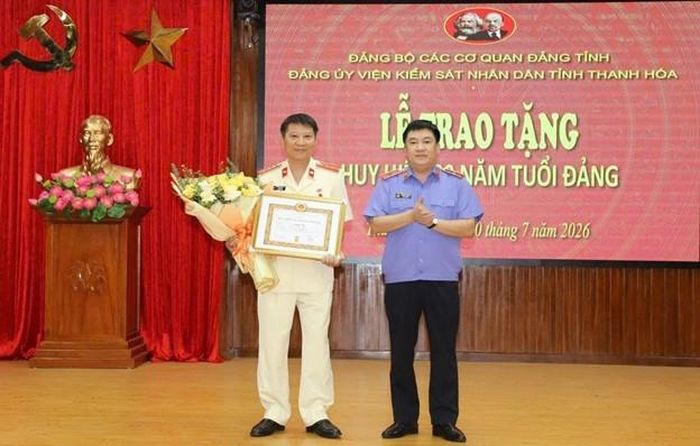  Đồng chí Nguyễn Tiến Dũng trao Huy hiệu 30 năm tuổi Đảng và tặng hoa chúc mừng.