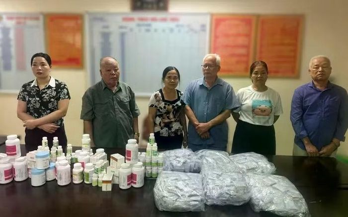 Các đối tượng cùng nhiều sản phẩm thuốc giả bị Cơ quan Công an phát hiện, thu giữ trong quá trình điều tra vụ án. (ảnh: CAHN)