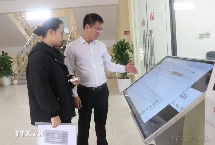 Hướng dẫn người dân phường Tam Sơn, tỉnh Bắc Ninh thực hiện thủ tục hành chính trên môi trường điện tử. (Ảnh: Thái Hùng/TTXVN)