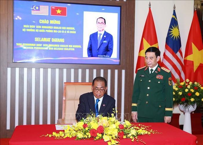 Ngài Dato Seri Mohamed Khaled Bin Nodrin, Bộ trưởng Quốc phòng Malaysia ghi sổ lưu niệm. Ảnh: Trọng Đức/TTXVN