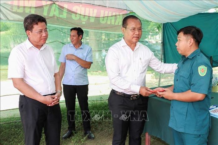 Trưởng Ban Quản lý Khu kinh tế tỉnh Tây Ninh Trương Thanh Liêm (thứ 2, trái sang) chia sẻ, động viên các lực lượng đang trực tiếp thực hiện nhiệm vụ lấy mẫu ADN phục vụ xác định danh tính hài cốt liệt sĩ tại Nghĩa trang liệt sĩ Đồi 82.
