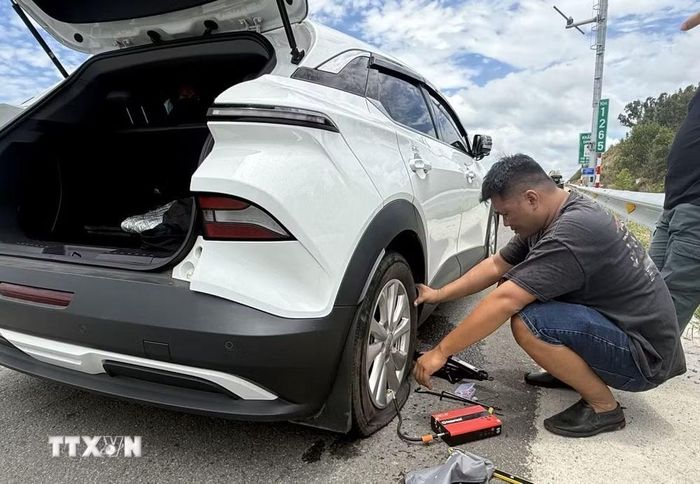 Ôtô con đâm phải vật sắt nhọn trên cao tốc Chí Thạnh-Vân Phong dừng ở làn khẩn cấp để sửa chữa. (Ảnh: Tường Quân/TTXVN)