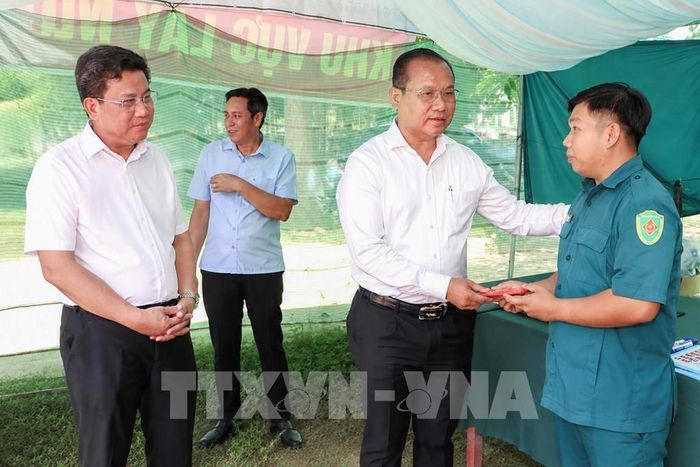 Trưởng Ban Quản lý Khu kinh tế tỉnh Tây Ninh Trương Thanh Liêm (thứ 2, trái sang) chia sẻ, động viên các lực lượng đang trực tiếp thực hiện nhiệm vụ lấy mẫu ADN phục vụ xác định danh tính hài cốt liệt sĩ tại Nghĩa trang liệt sĩ Đồi 82. Ảnh: Giang Phương – TTXVN