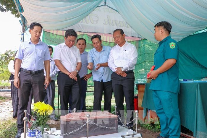 Phó Chủ tịch UBND xã Tân Biên Trần Đức Tuấn (thứ 3, phải sang) báo cáo về công tác lấy mẫu ADN phục vụ công tác xác định danh tính hài cốt liệt sĩ. Ảnh: Giang Phương – TTXVN