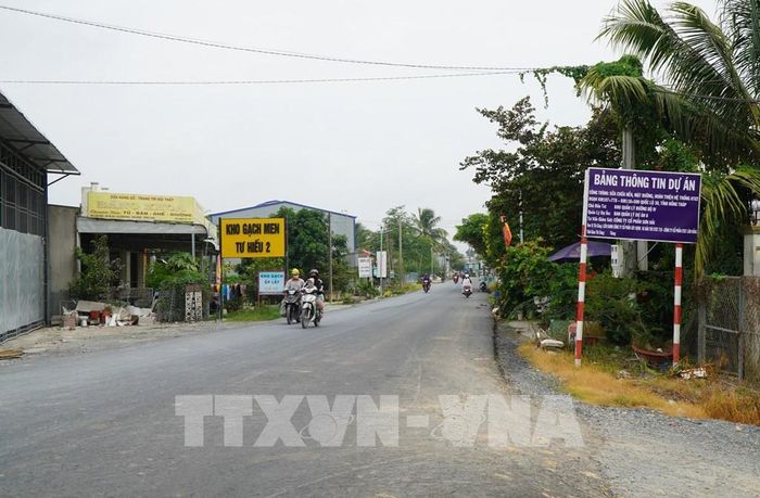 Người dân rất phấn khởi vì một đoạn thuộc Dự án sửa chữa Quốc lộ 30 đã được thảm nhựa. Ảnh: Nhựt An - TTXVN