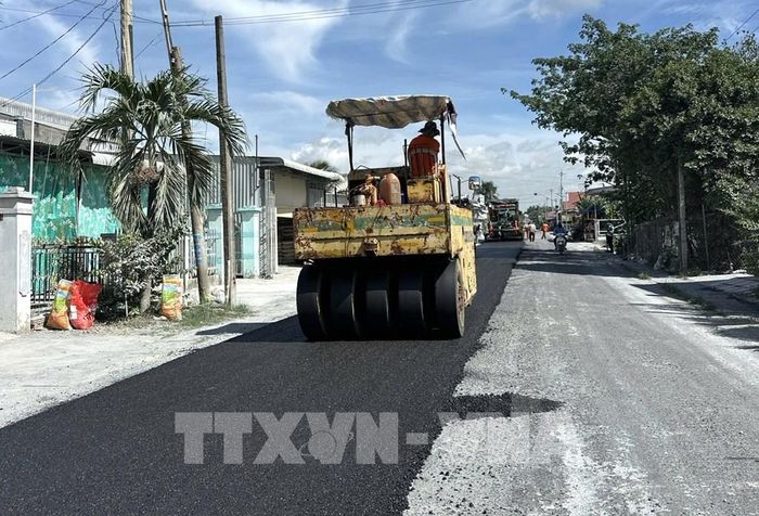 Tranh thủ thời tiết khô ráo, nhà thầu triển khai thảm nhựa Quốc lộ 30, đoạn qua ấp Gò Da, xã Tân Hồng. Ảnh: Nhựt An - TTXVN